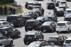 Các tài xế taxi chặn tuyến đường Porte Maillot trong cuộc biểu tình phản đối dịch vụ taxi giá rẻ UberPop ở Paris ngày 25/6. (Nguồn: AFP/TTXVN)