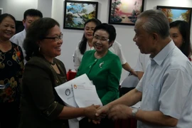 Chủ tịch Hội khuyến học Việt Nam Nguyễn Mạnh Cầm trao quà hỗ trợ cho đại diện các tỉnh, thành khu vực miền Trung. (Ảnh: Đức Thọ/TTXVN)