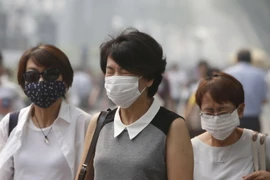 Người dân Singapore đeo khẩu trang để đối phó với tình trạng ô nhiễm khói bụi. (Nguồn: Reuters/TTXVN)