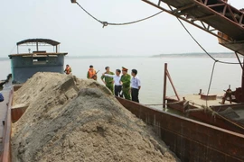 Đội Cảnh sát Môi trường Công an huyện Phúc Thọ xử lý doanh nghiệp khai thác cát trái phép. (Ảnh: Doãn Tuấn/TTXVN)
