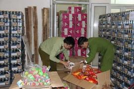 Công an Hà Nội kiểm tra lô hàng bánh kẹo lậu của Trung Quốc chưa rõ chất lượng. (Ảnh: Doãn Tuấn/TTXVN)