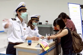 Hành khách từ Hàn Quốc nhập cảnh đến Việt Nam thực hiện kê khai tờ khai y tế. (Ảnh: Dương Ngọc/TTXVN)