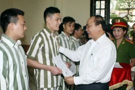 Phó Thủ tướng Nguyễn Xuân Phúc trao Quyết định đặc xá của Chủ tịch nước cho người được đặc xá. (Ảnh: Phạm Kiên/TTXVN)