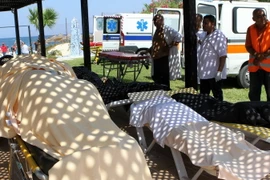 Nhân viên y tế Tunisia bên thi thể các nạn nhân vụ xả súng ngày 26/6. (Nguồn: AFP/TTXVN)