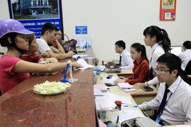 Khách hàng giao dịch tại Sacombank chi nhánh Lạng Sơn. (Ảnh: Trần Việt/TTXVN)