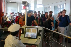 Kiểm tra thân nhiệt hành khách qua Cửa khẩu quốc tế Mộc Bài, Tây Ninh. (Ảnh: Nguyễn Thanh Tân/TTXVN)