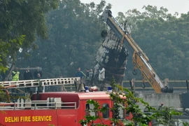 Lực lượng cứu hộ làm nhiệm vụ tại hiện trường vụ tai nạn. (Nguồn: AFP/TTXVN)