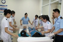 Cấp cứu công nhân Công ty Chánh Ích nghi ngộ độc thực phẩm tại Bệnh viện Đa khoa Đồng Nai. (Ảnh: Sỹ Tuyên/TTXVN)