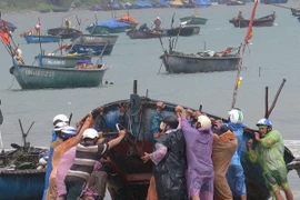 Ngư dân đưa thuyền lên bờ tránh bão số 3. (Ảnh: Văn Sơn/TTXVN)