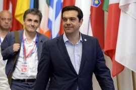 Thủ tướng Hy Lạp Alexis Tsipras (phải) và Bộ trưởng Tài chính Euclide Tsakalotos rời khỏi Hội nghị thượng đỉnh Eurozone tại Brussels ngày 13/7. (Nguồn: AFP/TTXVN)