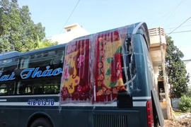 Một xe khách bị ném đá vỡ kính phải che tạm thời bằng chăn. (Ảnh: Phạm Cường/TTXVN)