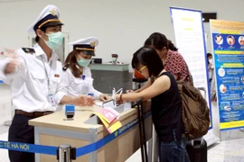 Hành khách từ Hàn Quốc nhập cảnh đến Việt Nam thực hiện kê khai y tế. (Ảnh: Dương Ngọc/TTXVN)