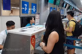 Hành khách mua vé máy bay của Vietnam Airlines. (Ảnh: Việt Hùng/Vietnam+)
