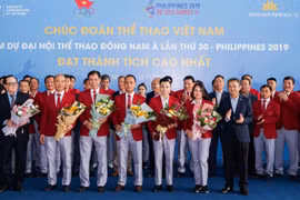 Ông Dương Trí Thành, Tổng giám đốc Vietnam Airlines (áo đen, ngoài cùng bên phải) tặng hoa và chúc mừng Đoàn thể thao Việt Nam gặt hái nhiều thành công tại SEA Games 30. (Ảnh: CTV/Vietnam+)
