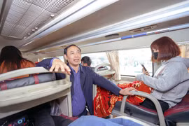 Thứ trưởng Bộ Giao thông Vận tải kiểm tra việc thắt dây an toàn của hành khách trên xe giường nằm. (Ảnh: Việt Hùng/Vietnam+)
