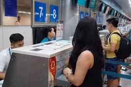 Hành khách mua vé máy bay của Vietnam Airlines. (Ảnh: Việt Hùng/Vietnam+)