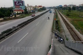 Lối lên xuống cầu vượt lại dẫn người đi bộ xuống thẳng lòng Quốc lộ 5 một cách rất... bất hợp lý (Ảnh: PV/Vietnam+)