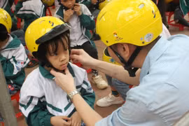 Trẻ em được đội mũ bảo hiểm đạt chuẩn sẽ giảm tỷ lệ chấn thương vùng đầu khi xảy ra tai nạn giao thông. (Ảnh: Việt Hùng/Vietnam+)