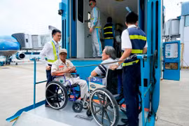 Khi hạ cánh, do phải di chuyển bằng xe lăn nên Vietnam Airlines phải bố trí xe nâng, hạ theo đúng tiêu chuẩn phục vụ người tàn tật. (Ảnh: Anh Tuấn/Vietnam+)