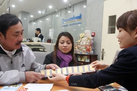 Khách hàng đang giao dịch vàng miếng tại hệ thống Sacombank (Ảnh: TTXVN)