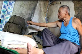 Ông Nguyễn Quang Thành, ở tổ 55, phường Hà Trung bên ngôi nhà nứt toác tường. (Ảnh: H.V/Vietnam+)