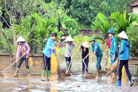 Người dân và các cơ quan chức năng thị trấn Cẩm Khê, huyện Cẩm Khê nỗ lực khắc phục hậu quả sau lũ. (Ảnh: Tạ Toàn/TTXVN)