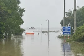 Tuyến đường về xã Vĩnh Long bị ngập sâu trong nước gây chia cắt. (Ảnh: Thanh Thủy/TTXVN)