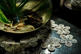 Từ những sợi bạc nhỏ như sợi tóc, người thợ kim hoàn Định Công chế tác các sản phẩm tinh xảo hình hoa, lá, cây, cỏ, động vật phục vụ nhu cầu thị trường. (Ảnh: Phạm Tuấn Anh /TTXVN)