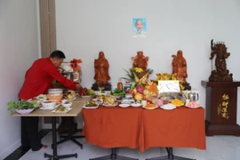 Ông Hòa cẩn thận bày biện bàn lễ cúng ông Công ông Táo. (Ảnh: Đỗ Sinh/TTXVN)