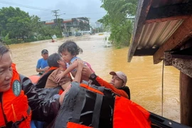 Lực lượng cứu hộ sơ tán em nhỏ khỏi vùng ngập lụt tại thị trấn Catarman, Philippines,. (Ảnh minh họa. AFP/TTXVN)