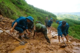 Cán bộ, chiến sỹ Ban Chỉ huy Quân sự huyện Mèo Vạc cùng lực lượng dân quân khơi thông tuyến đường vào thôn Khuổi Roài, xã Tát Ngà bị cô lập do mưa lũ. (Ảnh: Hà Linh/TTXVN phát)