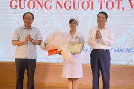 Bí thư Thành ủy Hải Phòng Lê Tiến Châu (trái) và Phó Chủ tịch Ủy ban Nhân dân thành phố Hải Phòng Lê Khắc Nam tặng Bằng khen cho điều dưỡng viên Nguyễn Thị Thảo. (Ảnh: Hoàng Ngọc/TTXVN)
