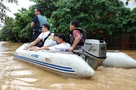 Lực lượng cứu hộ đưa người dân ra khỏi khu vực ngập lụt. Ảnh: Tuấn Anh/TTXVN()