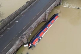 Một chiếc thuyền bị mắc kẹt tại cây cầu đường bộ bắc qua sông Soar ở Barrow sau trận mưa lũ. (Nguồn: Getty Images)