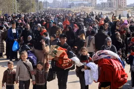 Người dân rời bỏ nhà cửa đi lánh nạn tại miền Nam Dải Gaza ngày 26/1. (Ảnh: AFP/TTXVN)