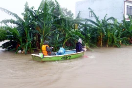 Người dân các địa phương huyện Lệ Thủy (Quảng Bình) dùng thuyền di chuyển trong vùng bị ngập lụt. (Ảnh: Tá Chuyên/TTXVN)