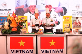 Chuyên gia cắt tỉa Phạm Văn Đông và đầu bếp Nguyễn Văn Thông giới thiệu sản phẩm được chế biến trực tiếp tại Lễ hội Ẩm thực Việt Nam. (Ảnh: Ngọc Thúy/TTXVN)