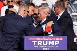 Ông Donald Trump được mật vụ Mỹ hộ tống khỏi sân khấu của sự kiện vận động tranh cử tại bang Pennsylvania sau khi xảy ra vụ nổ súng, ngày 13/7. (Ảnh: IRNA/TTXVN)