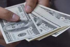 Đồng tiền mệnh giá 100 USD. (Ảnh: AFP/TTXVN)
