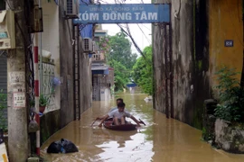 Người dân xã Đồng Bẩm, thành phố Thái Nguyên phải di chuyển bằng thuyền. (Ảnh: Thu Hằng/TTXVN)