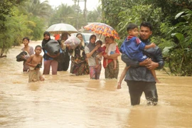 Người dân sơ tán khỏi vùng ngập lụt tại Narathiwat, Thái Lan. (Ảnh: THX/TTXVN)