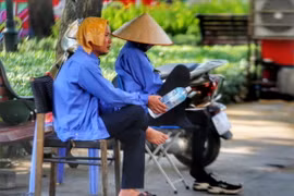 Cái khăn mặt ướt cùng chai nước là vật không thể thiếu của những nhân viên trông xe vỉa hè. (Ảnh: Tuấn Đức/TTXVN)