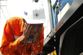 Công nhân điện lực giải nhiệt tạm thời trong quá trình thi công dưới trời nắng nóng trên 41 độ C tại Thành phố Hồ Chí Minh. (Ảnh: Thanh Vũ/TTXVN)