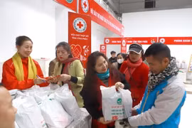 Người có hoàn cảnh khó khăn được nhận quà ở gian hàng tại “Chợ Tết nhân ái." (Ảnh: Hoàng Hùng/TTXVN)