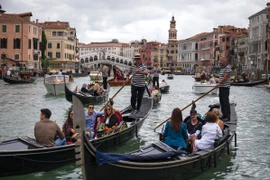 Du khách đi thuyền gondola tại Venice, Italy. (Ảnh: AFP/TTXVN)