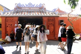 Du khách trong và ngoài nước tham quan Chùa Cầu sau khi được trùng tu. (Ảnh: Trịnh Bang Nhiệm/TTXVN)