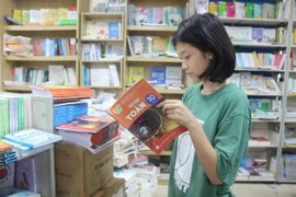 Học sinh chọn mua sách. (Ảnh: Bích Huệ/TTXVN)