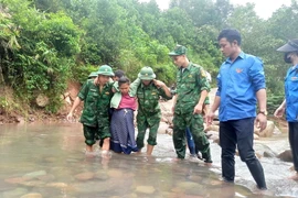 Các lực lượng hỗ trợ người dân qua lại ngầm tràn, điểm giao thông đảm bảo an toàn. (Ảnh: TTXVN phát)