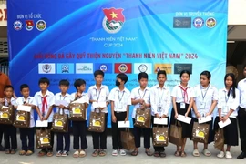 Trao quà và học bổng cho con em người gốc Việt tại Trường Tiểu học Hữu nghị Khmer-Việt Nam Tân Tiến. (Ảnh: Hoàng Minh/TTXVN)
