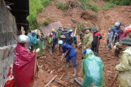 Lực lượng chức năng tổ chức cứu hộ, cứu nạn các nạn nhân sạt lở đất tại Bắc Hà, Lào Cai. (Ảnh: TTXVN phát)